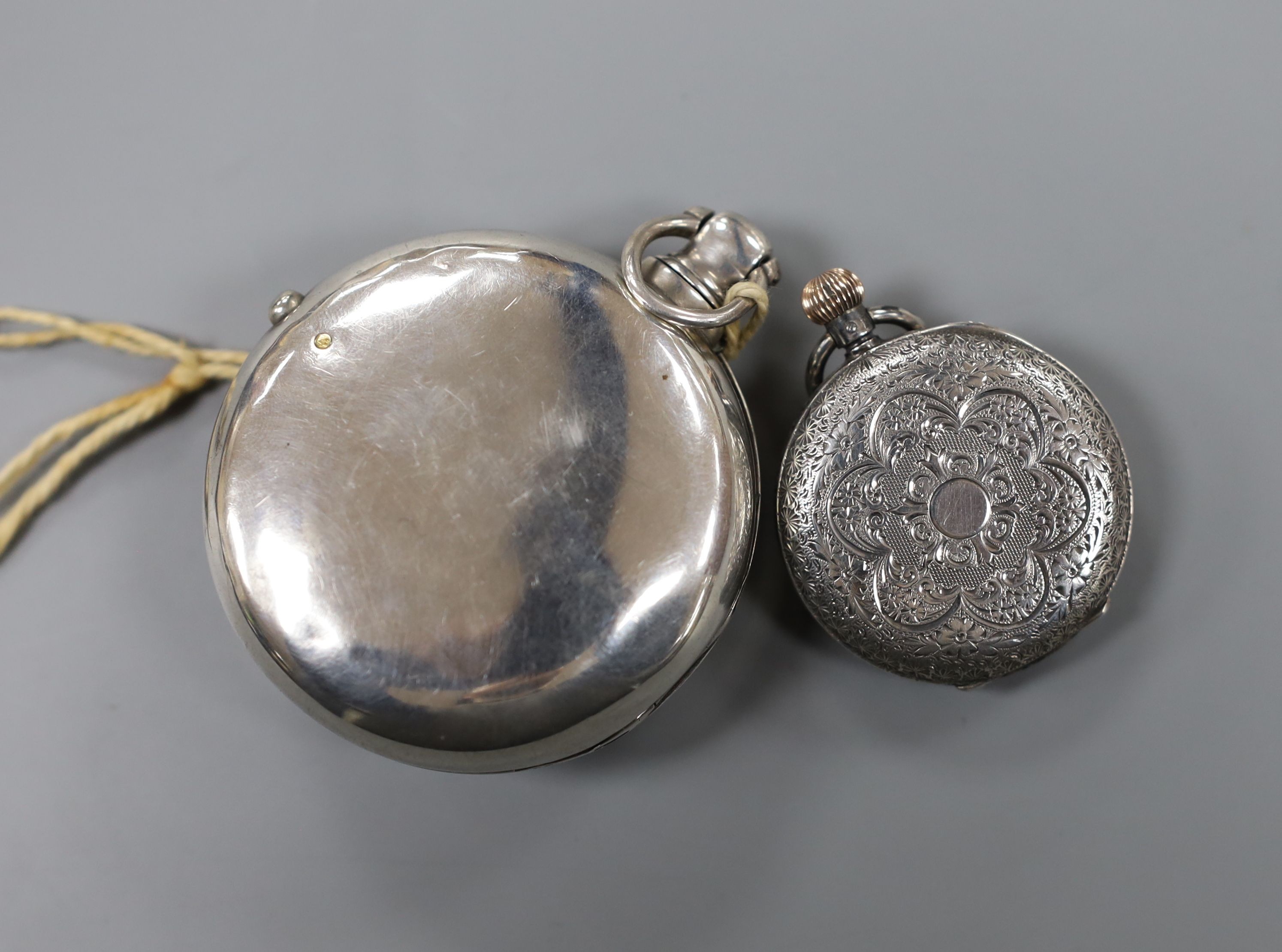 A 19th century silver pair cased half hunter keywind pocket watch, with two Roman dials, overall diameter 55mm, and a later engraved silver fob watch.